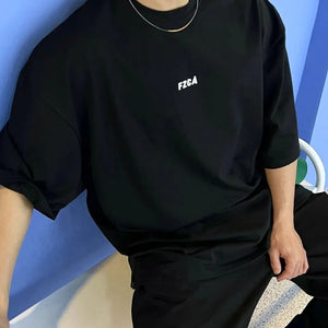 Black oversized tee with drop shoulder and small white logo detail