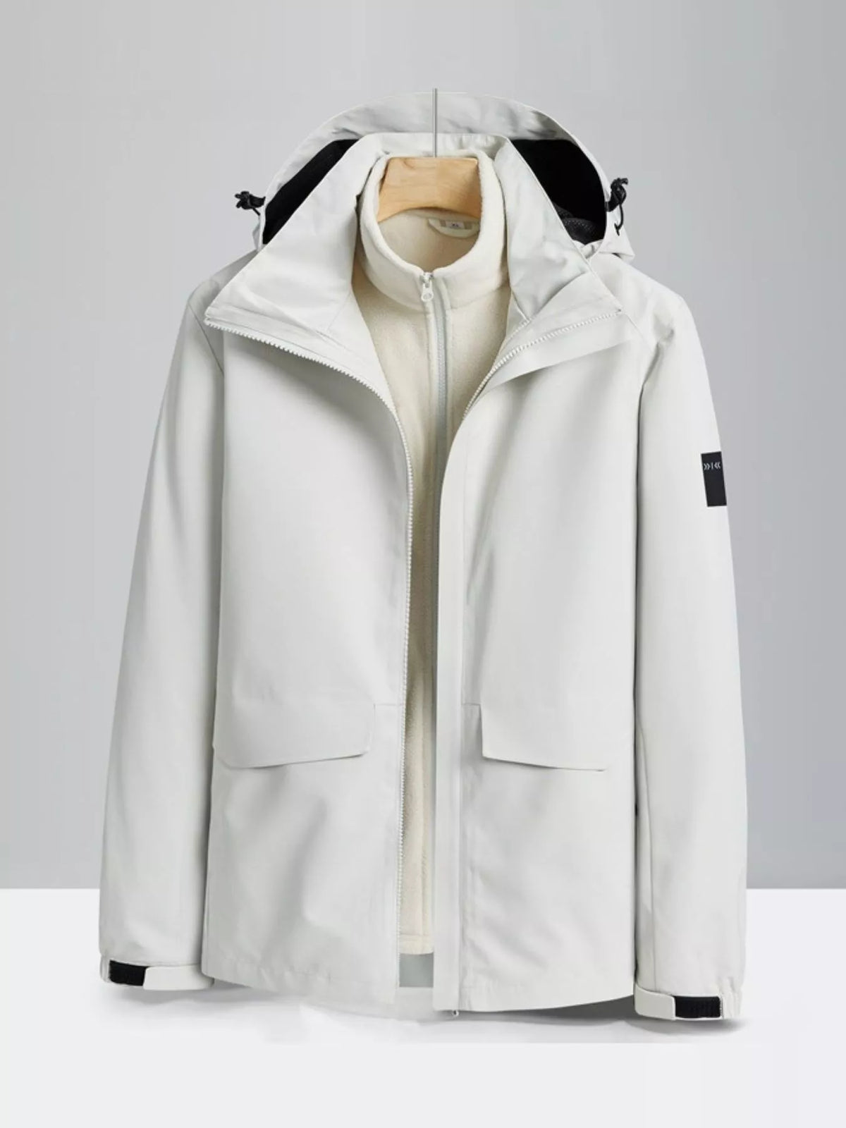 White hooded waterproof jacket with zip-out fleece liner and two front pockets.