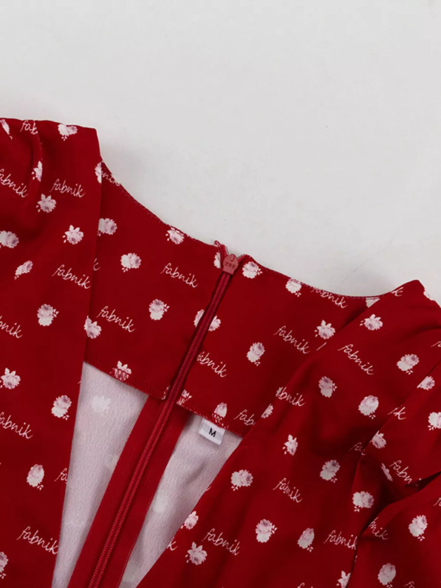 Red floral print dress with white text pattern and zipper closure
