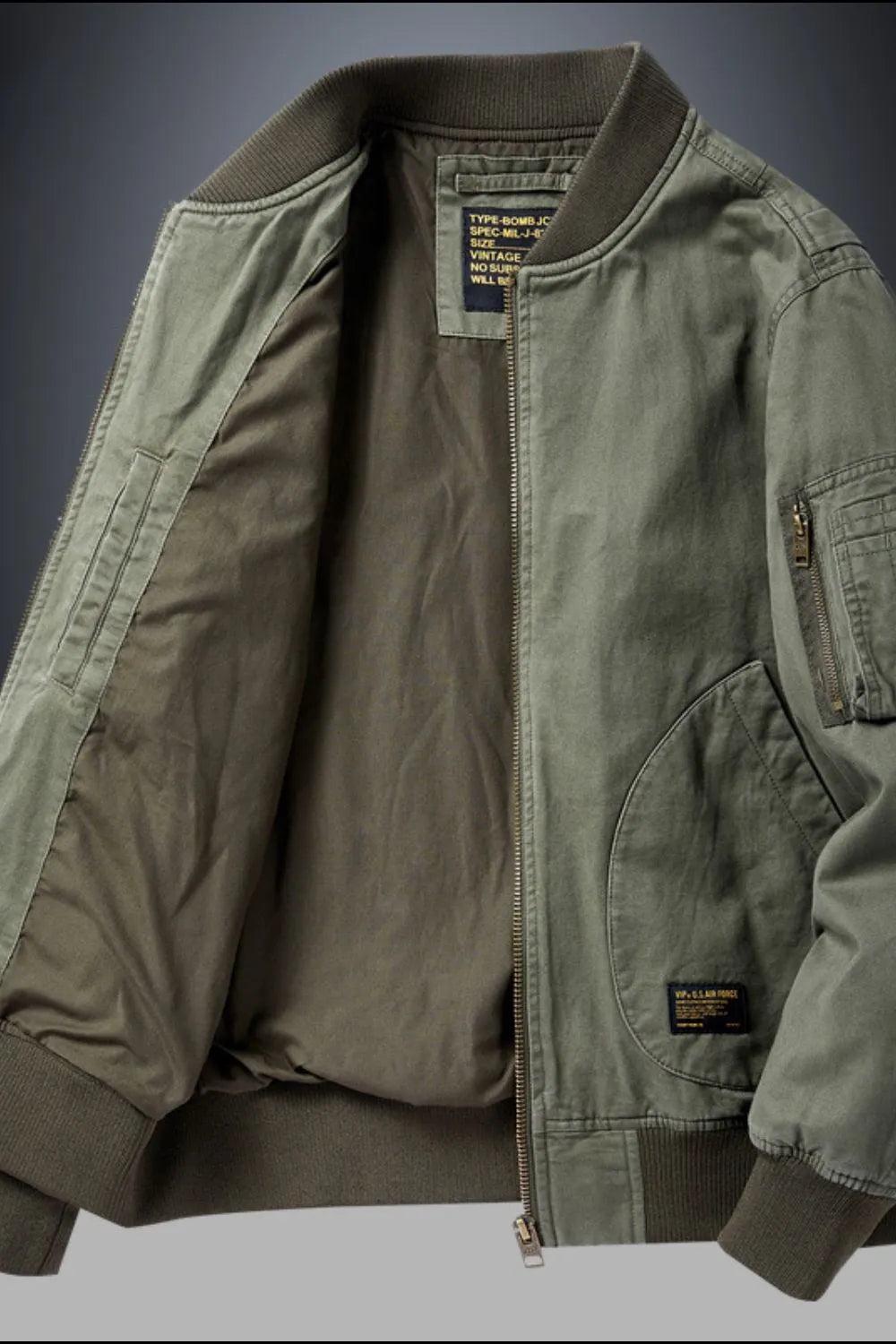 Army green bomber jacket with patch detail and zippered sleeve pocket.