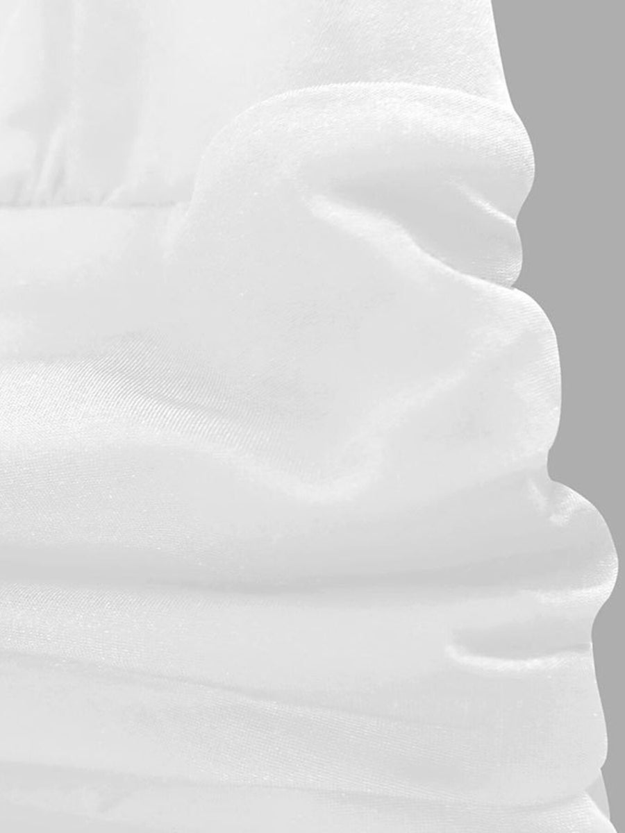 White ruffle hem dress detail showing textured fabric and layered ruffles.