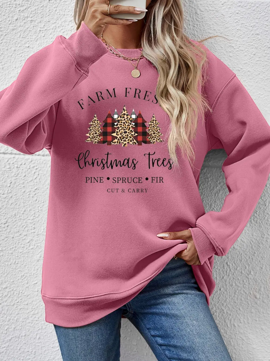 Blush pink crewneck sweatshirt with Christmas trees graphic and text.