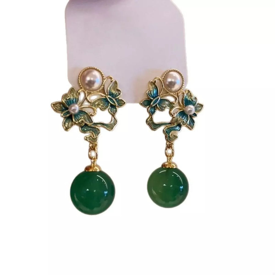 Dark green butterfly pearl drop earrings with floral accents.