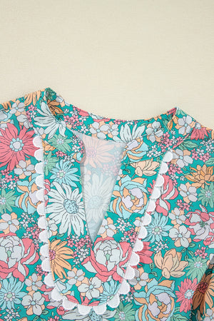 Floral peplum blouse with scallop trim and V-neckline.