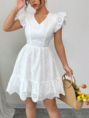 White eyelet mini dress with ruffle sleeves and tiered hem