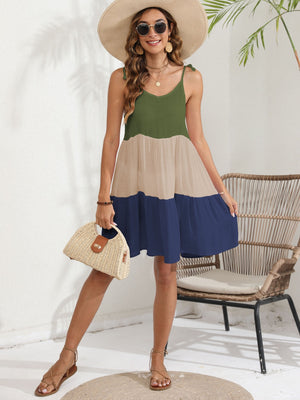 Tiered summer dress with green, tan, and dark blue colorblock, spaghetti straps, and tie details.
