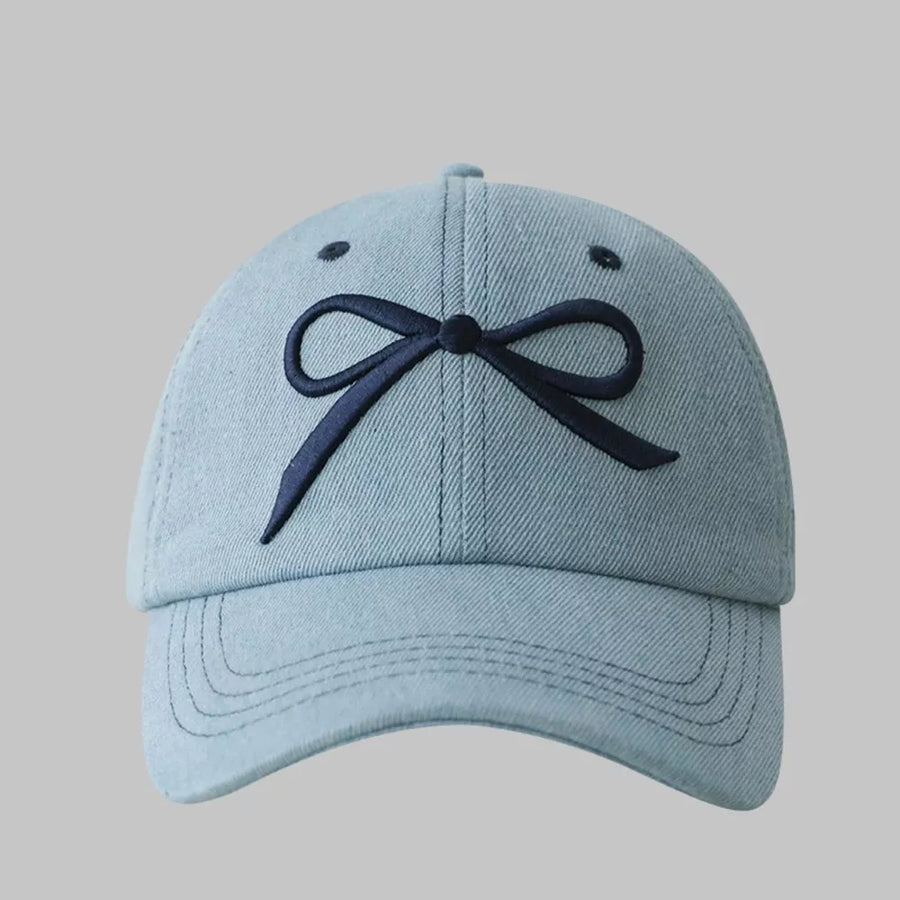 Light blue baseball cap with embroidered dark blue bow accent.