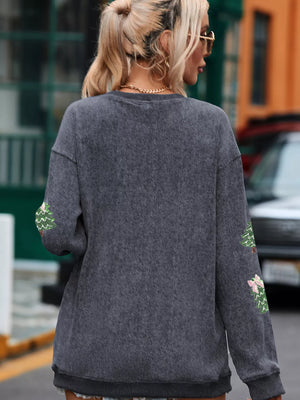 Dark gray baggy sweatshirt with embroidered Christmas trees on sleeves.