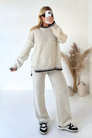 Beige knit sweater set with contrast black trim on neckline, cuffs, and hem