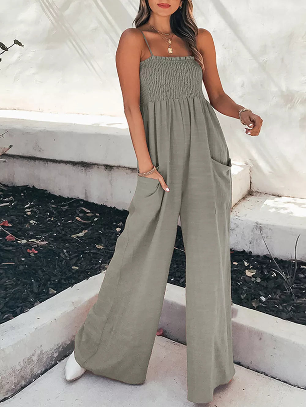 Gray smocked wide leg romper with pockets and spaghetti straps.