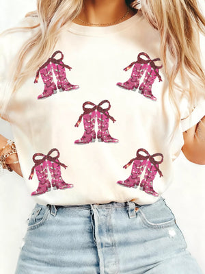White graphic tee with allover pink sequined cowgirl boots print and bow detail.