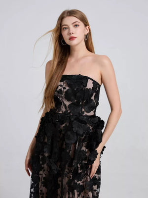 Black strapless midi dress with intricate floral applique and tiered skirt.