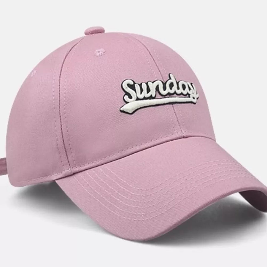 Pink baseball cap with embroidered white "Sunday" text and adjustable strap