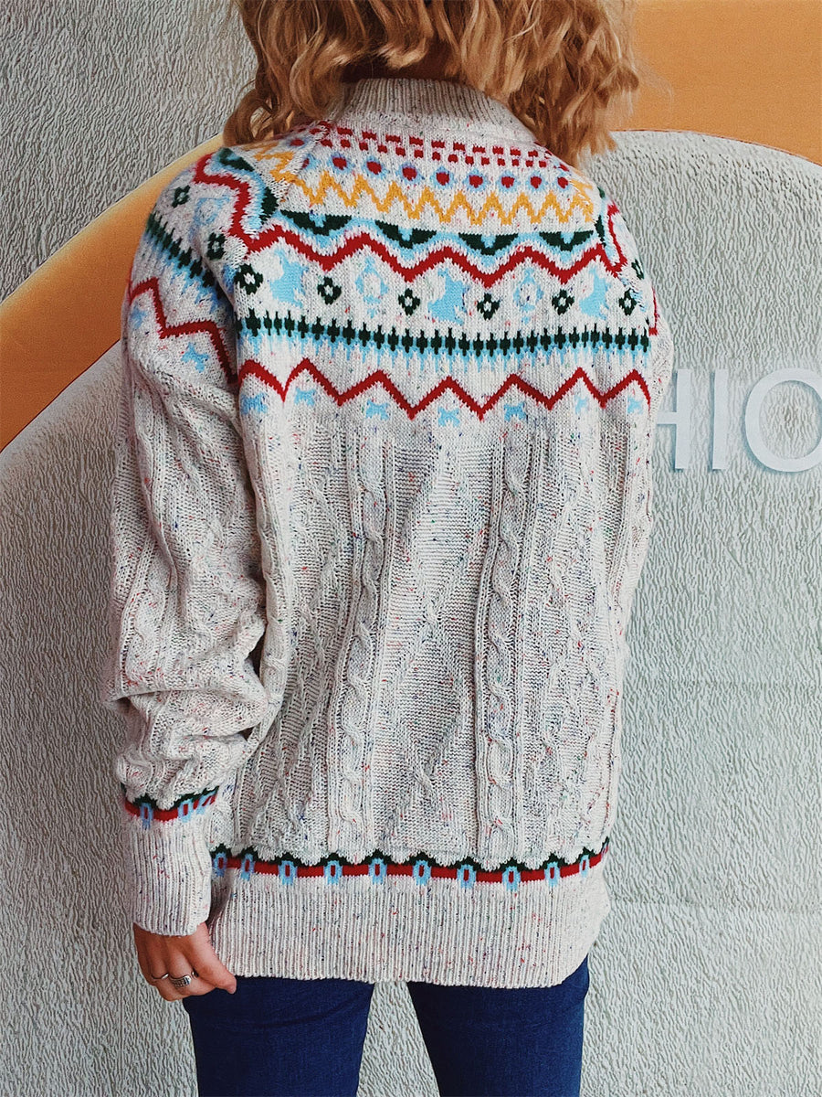 Beige cable knit turtleneck sweater with Fair Isle pattern and speckles.
