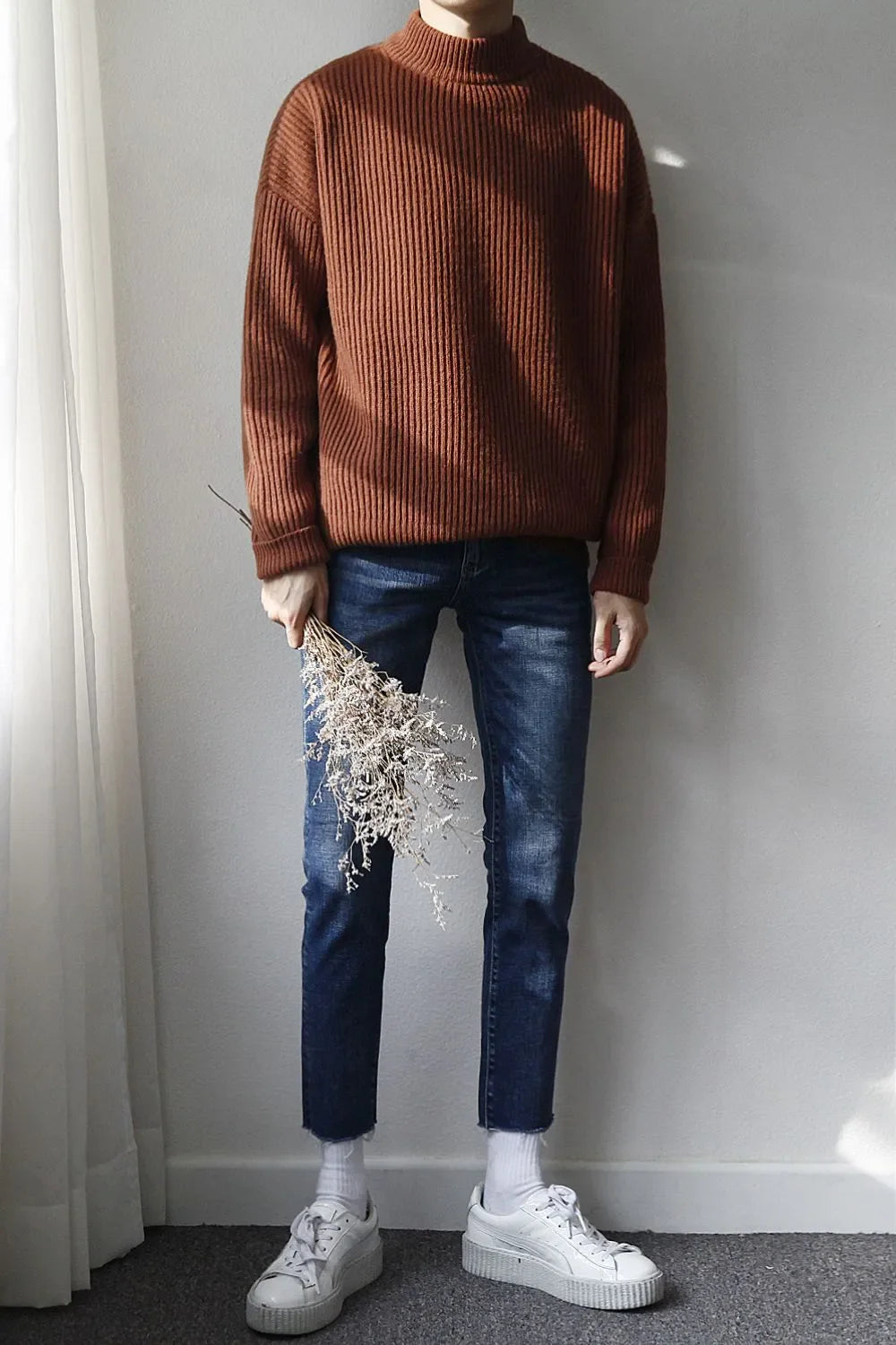 Slim-fit jeans in medium wash denim with a raw hem and a slight crop.