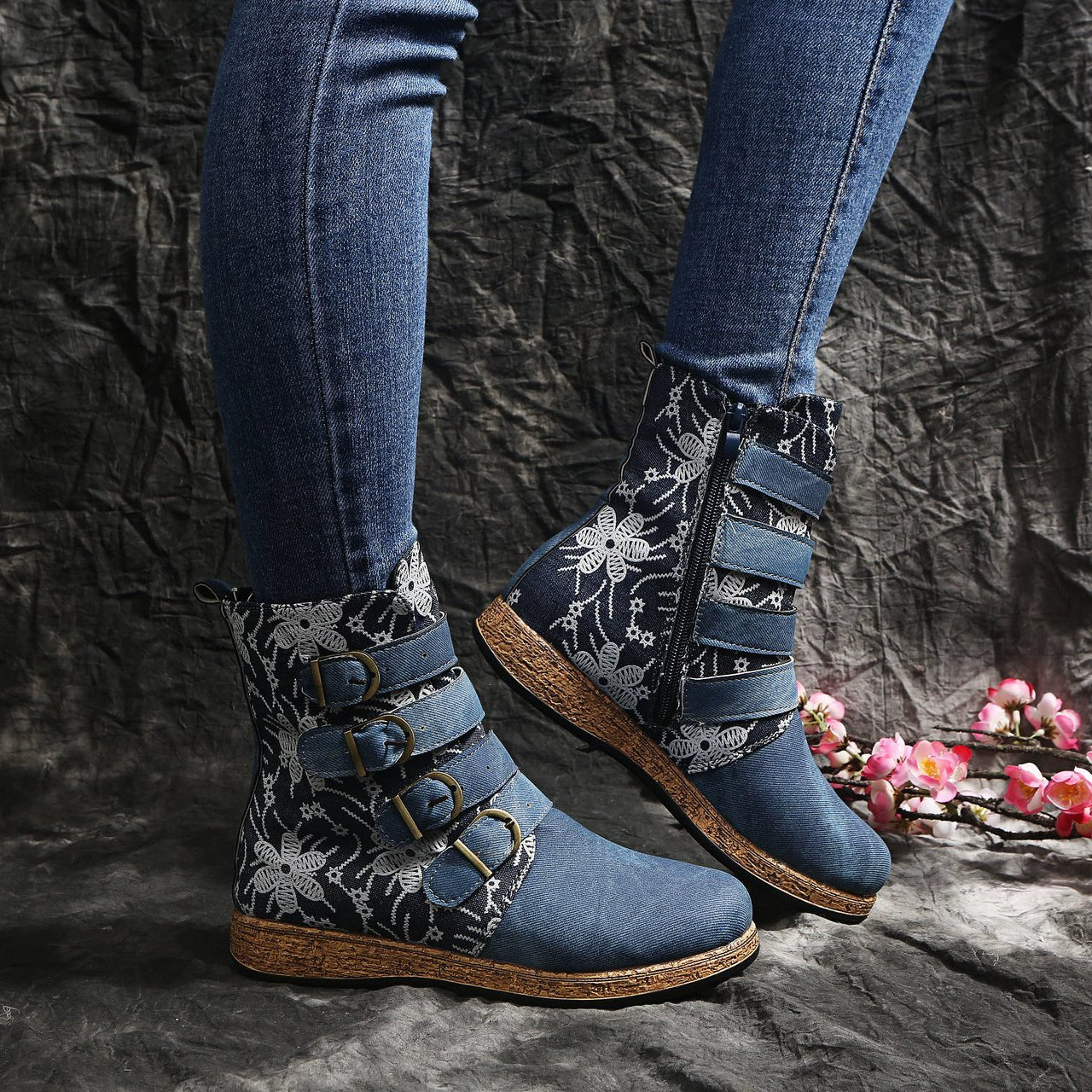 Blue embroidered suede ankle boots with floral accents and decorative straps.