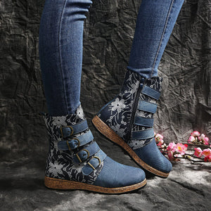 Blue embroidered suede ankle boots with floral accents and decorative straps.