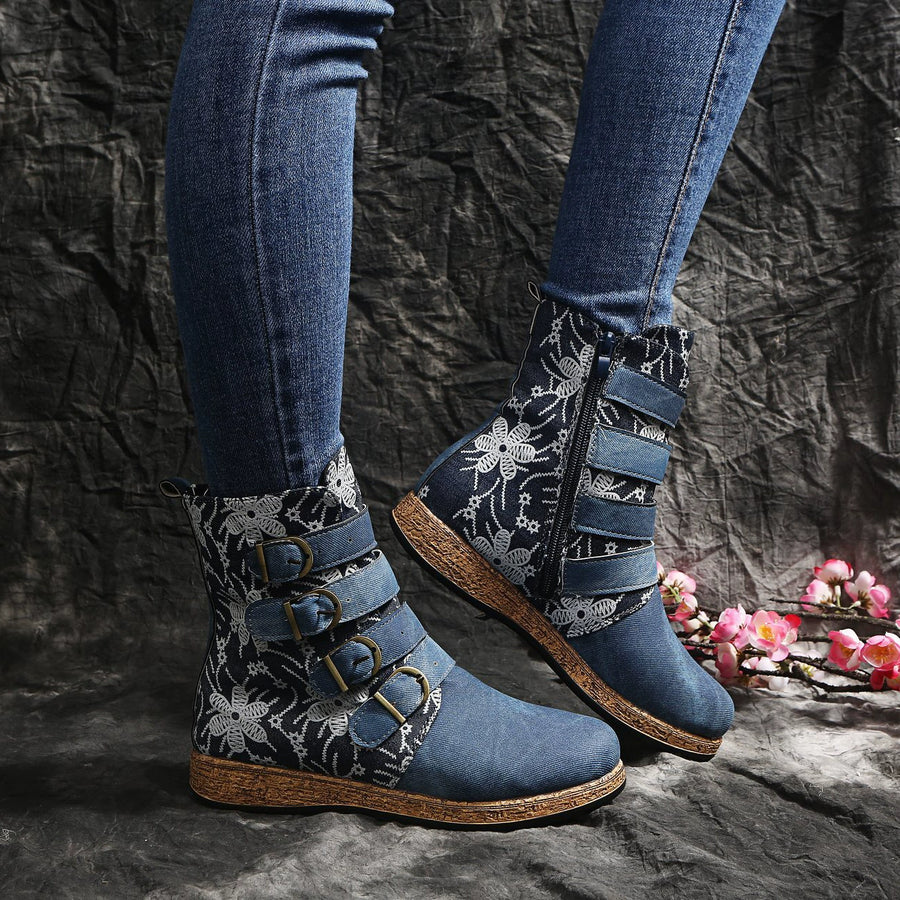 Blue embroidered suede ankle boots with floral accents and decorative straps.