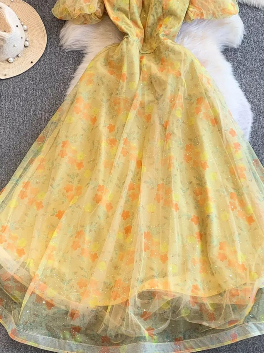 Yellow floral maxi dress with sweetheart neckline and sheer overlay.