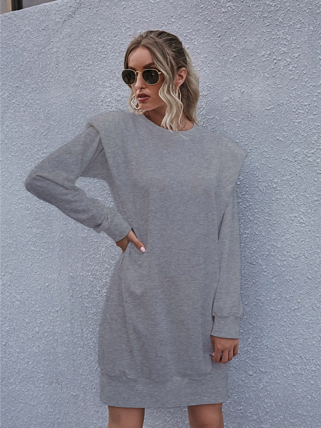 Grey sweatshirt mini dress with padded shoulders and long sleeves.