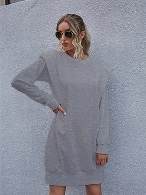 Grey sweatshirt mini dress with padded shoulders and long sleeves.