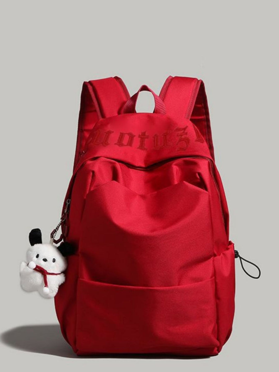 Red nylon drawstring backpack with padded straps and plush charm
