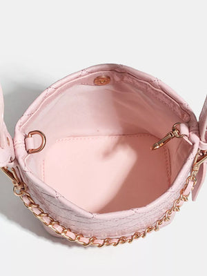 Pink quilted bucket bag with gold chain accent and snap closure.