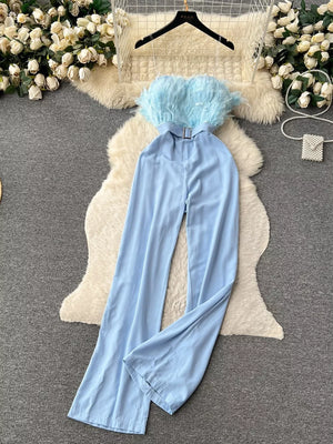 Blue strapless wide-leg jumpsuit with feather trim and belted waist.
