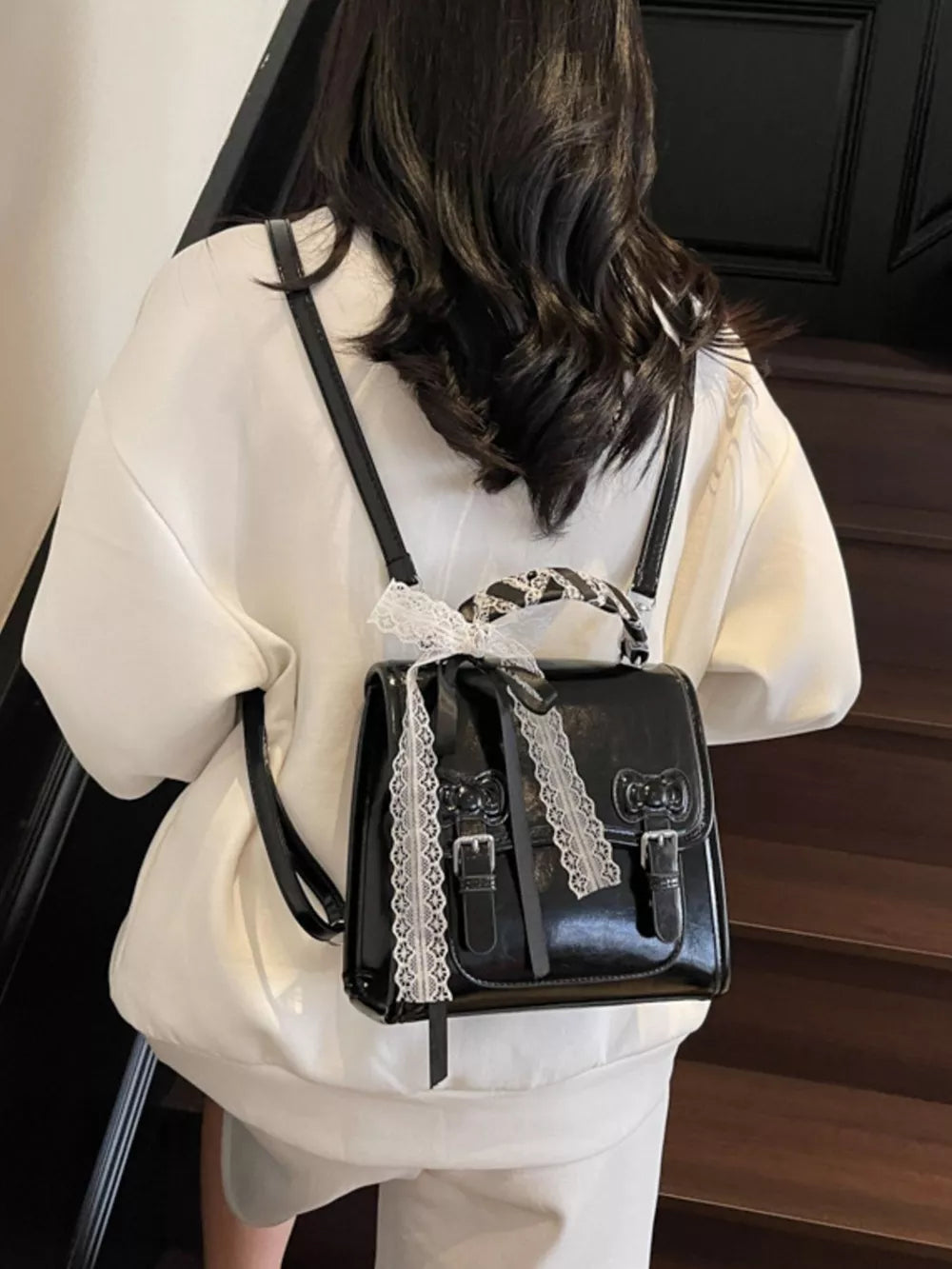 backpack in black featuring buckle straps and boxy fit