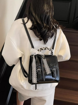 backpack in black featuring buckle straps and boxy fit