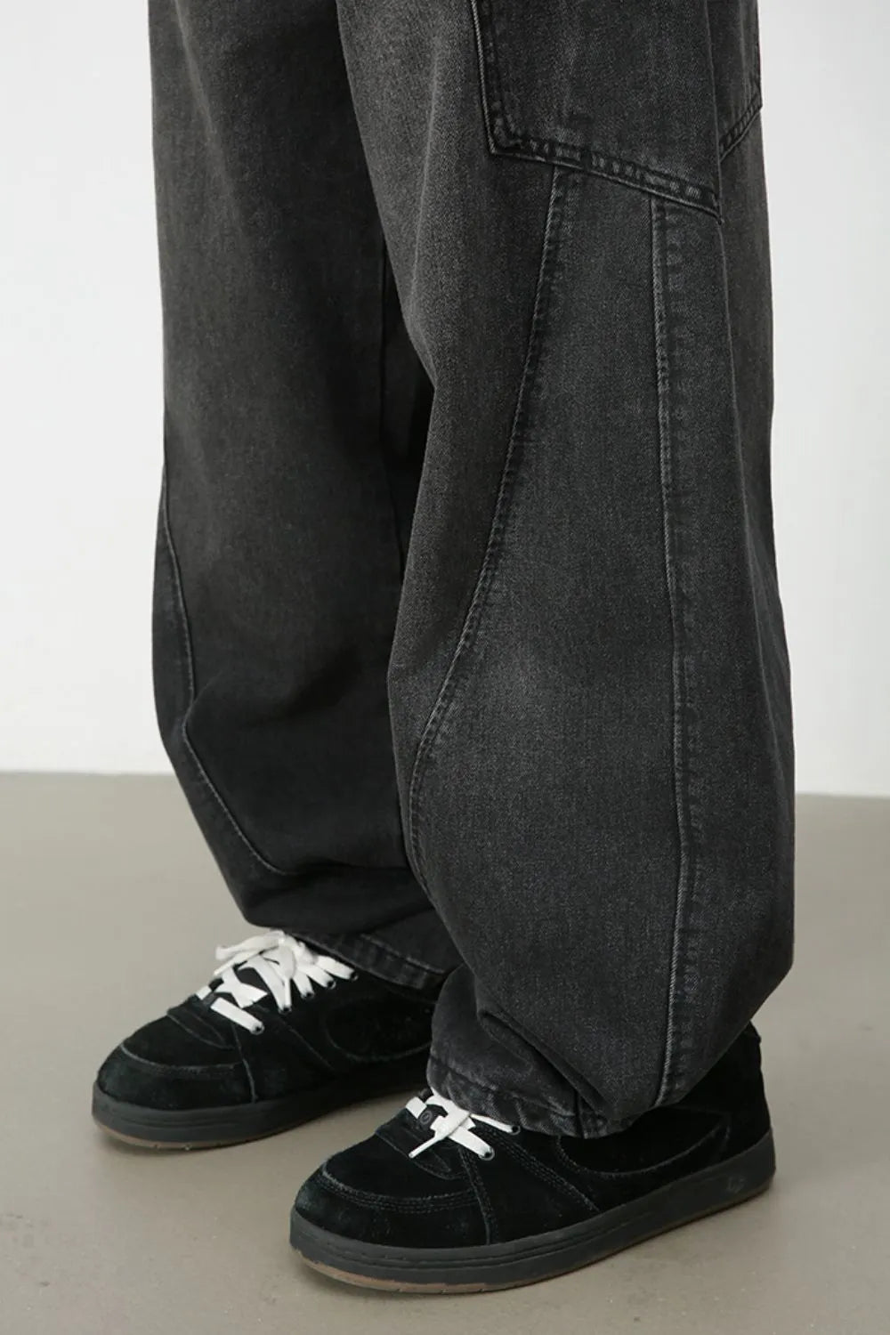 Black denim baggy trousers with sculpted seams and a relaxed fit.