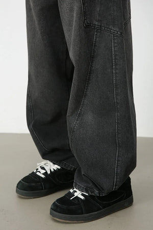Black denim baggy trousers with sculpted seams and a relaxed fit.