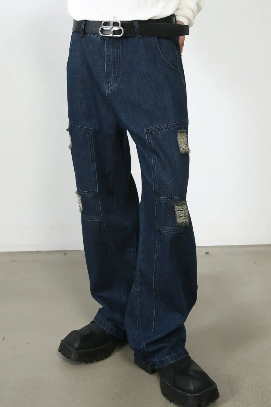 Dark wash denim wide-leg jeans with distressed panel pockets and a casual fit.