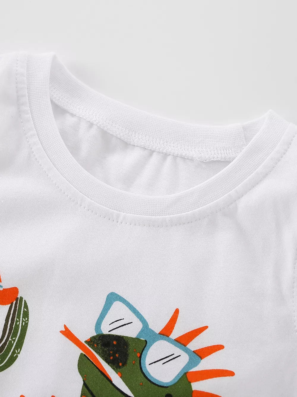 White cotton toddler t-shirt with a green lizard graphic wearing blue sunglasses.