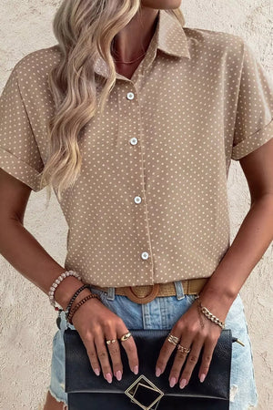 Chic polka dot button-up shirt with cuffed short sleeves and a collared neckline.