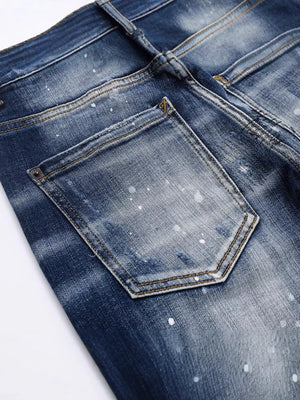 Men's dark blue distressed slim-fit jeans with paint splatter detail.