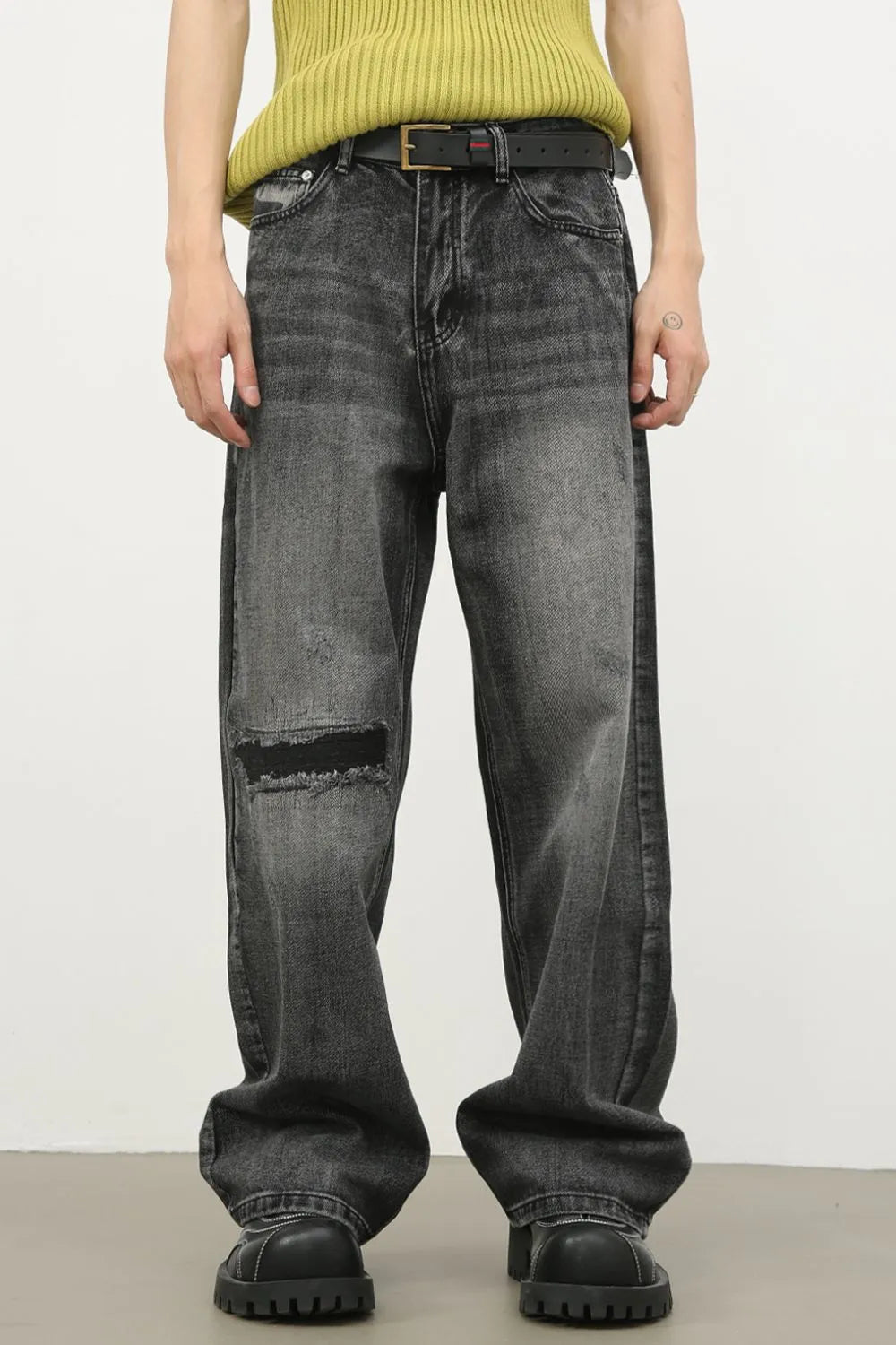 Baggy fit dark washed denim jeans with knee rips and a distressed look.