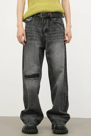 Baggy fit dark washed denim jeans with knee rips and a distressed look.