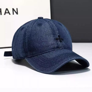 Dark blue denim baseball hat with embroidered detail and adjustable strap.