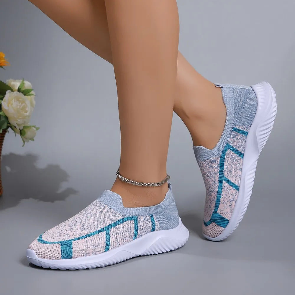 Geometric knit slip-on trainers in light gray and yellow with blue accents.