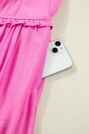 Pink ruffled sleeveless maxi dress with smocked waist and side pocket detail.