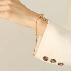 Gold slider bracelet with adjustable chain and charm detail