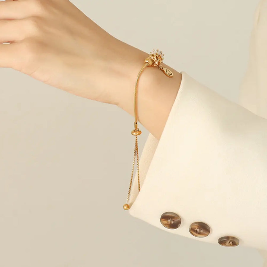 Gold slider bracelet with adjustable chain and charm detail