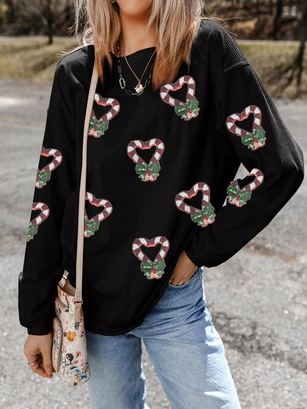 Black sweatshirt with sequin candy cane heart pattern, drop shoulder, crew neck.