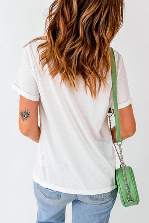 White graphic t-shirt with rolled sleeves and a subtle eye tattoo on the arm.