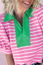 Pink and white striped cotton polo shirt with a green collar and placket detail.