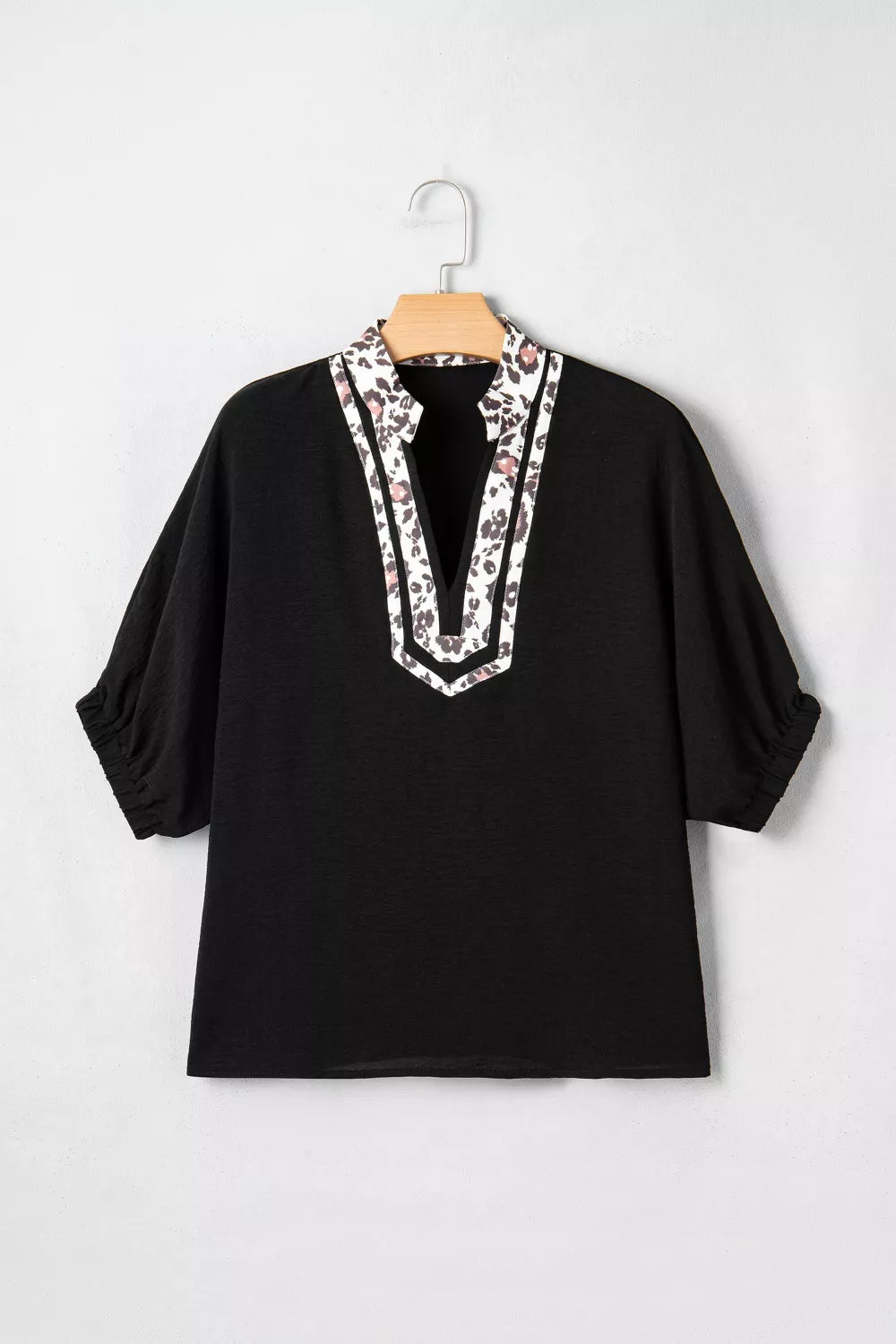 Black tunic shirt with leopard print notched neckline and short sleeves