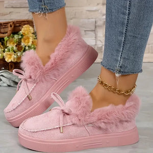 Pale blush suede loafers with shearling trim and bow detail.