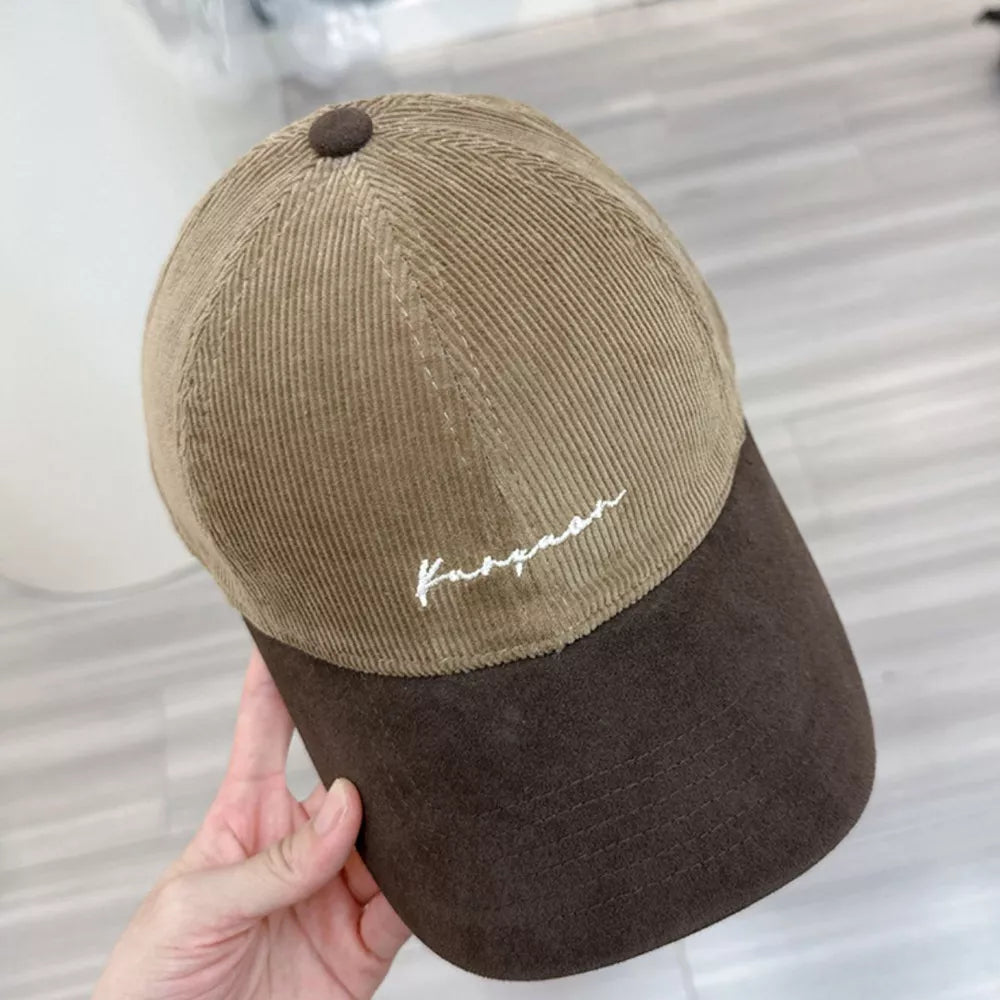 Two-tone corduroy baseball hat in camel and dark brown with white embroidery.