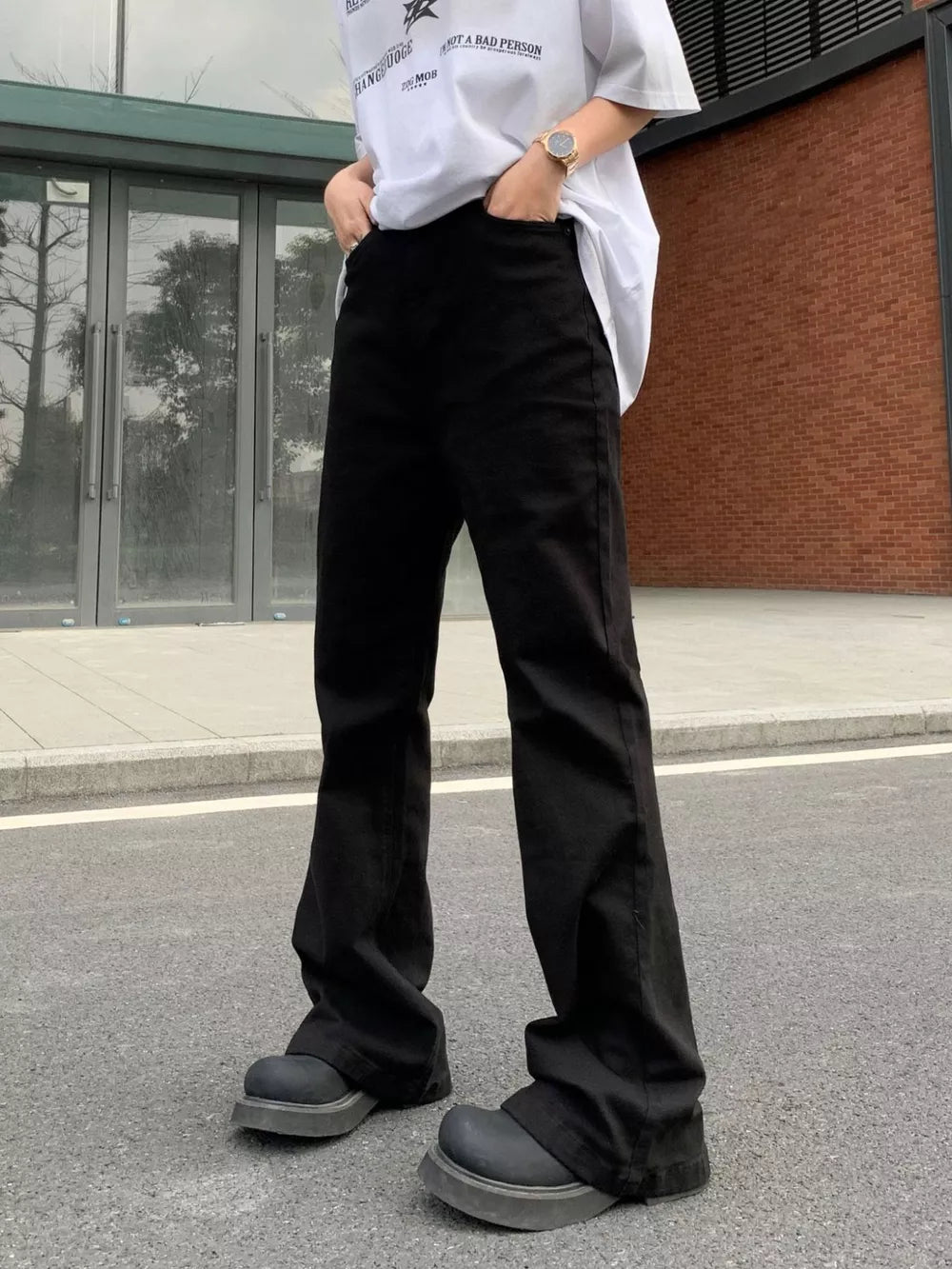 Men's black high-waisted flare leg trousers with a casual streetwear style.
